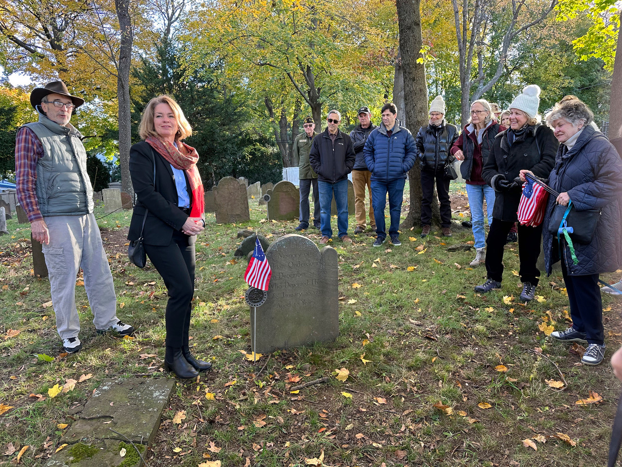 Town Historian Ross Lumpkin and Supervisor DeSena planting American flags at revolutionary war graves at Montfort Cemetery in Port Washington