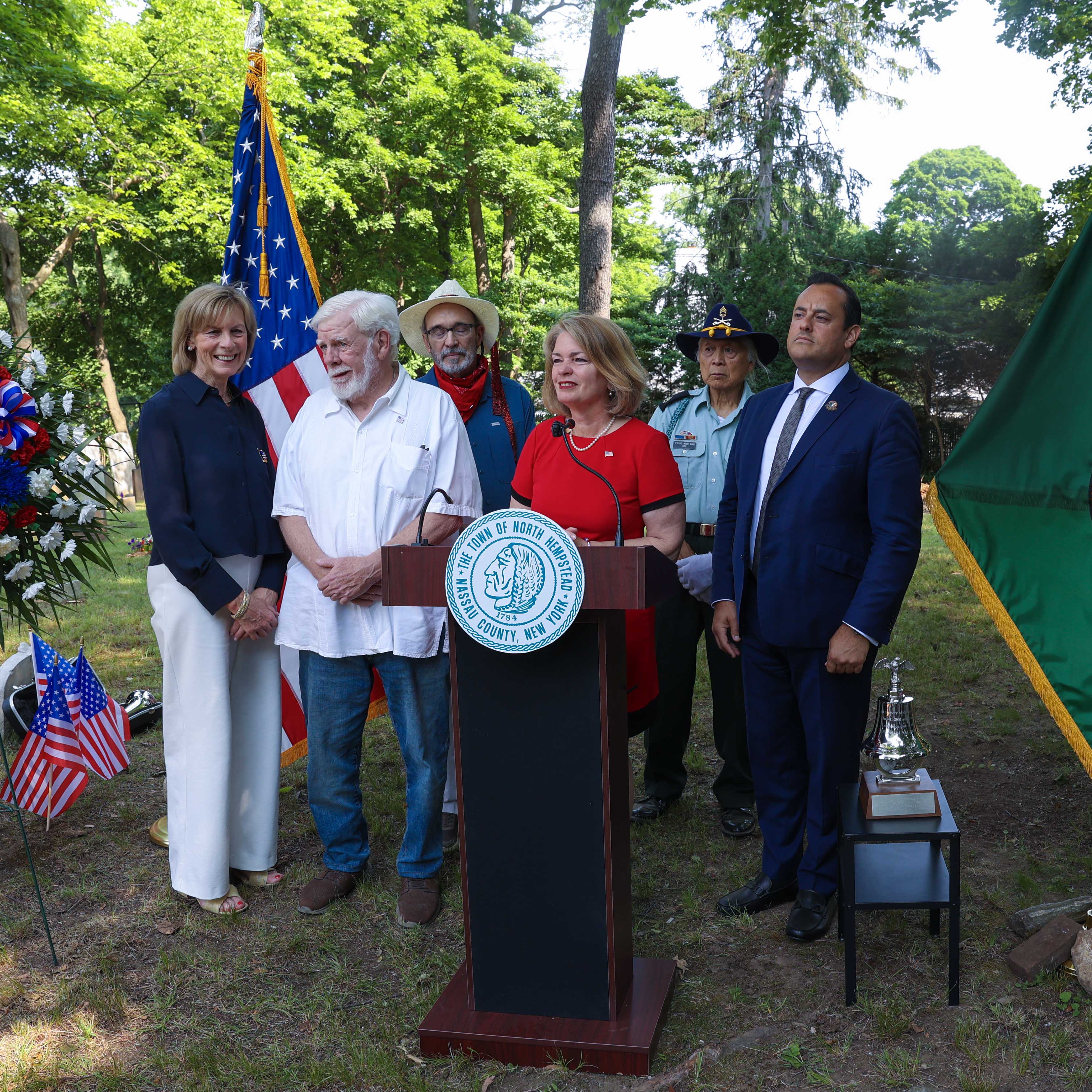 Supervisor Jennifer S. DeSena addresses attendees at the podium during the Monfort Cemetery ceremony.